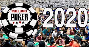 A large crowd at a poker tournament sits at tables under bright lights. In the foreground, a large poker chip marks the 2020 contest, highlighting one of the most anticipated poker events of the World Series of Poker.